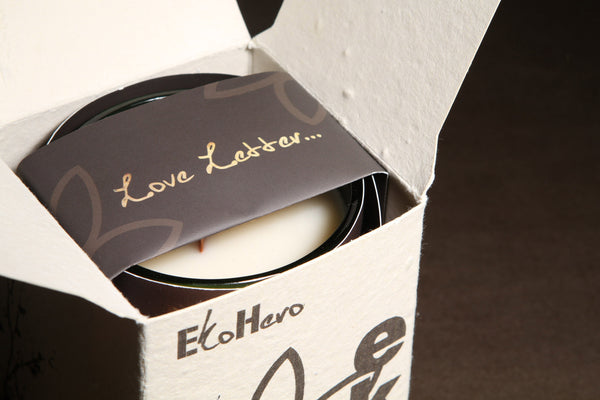 Seed box containing an EkoMiko Candle with coco butter wax that has a love letter across it made out of stone paper.